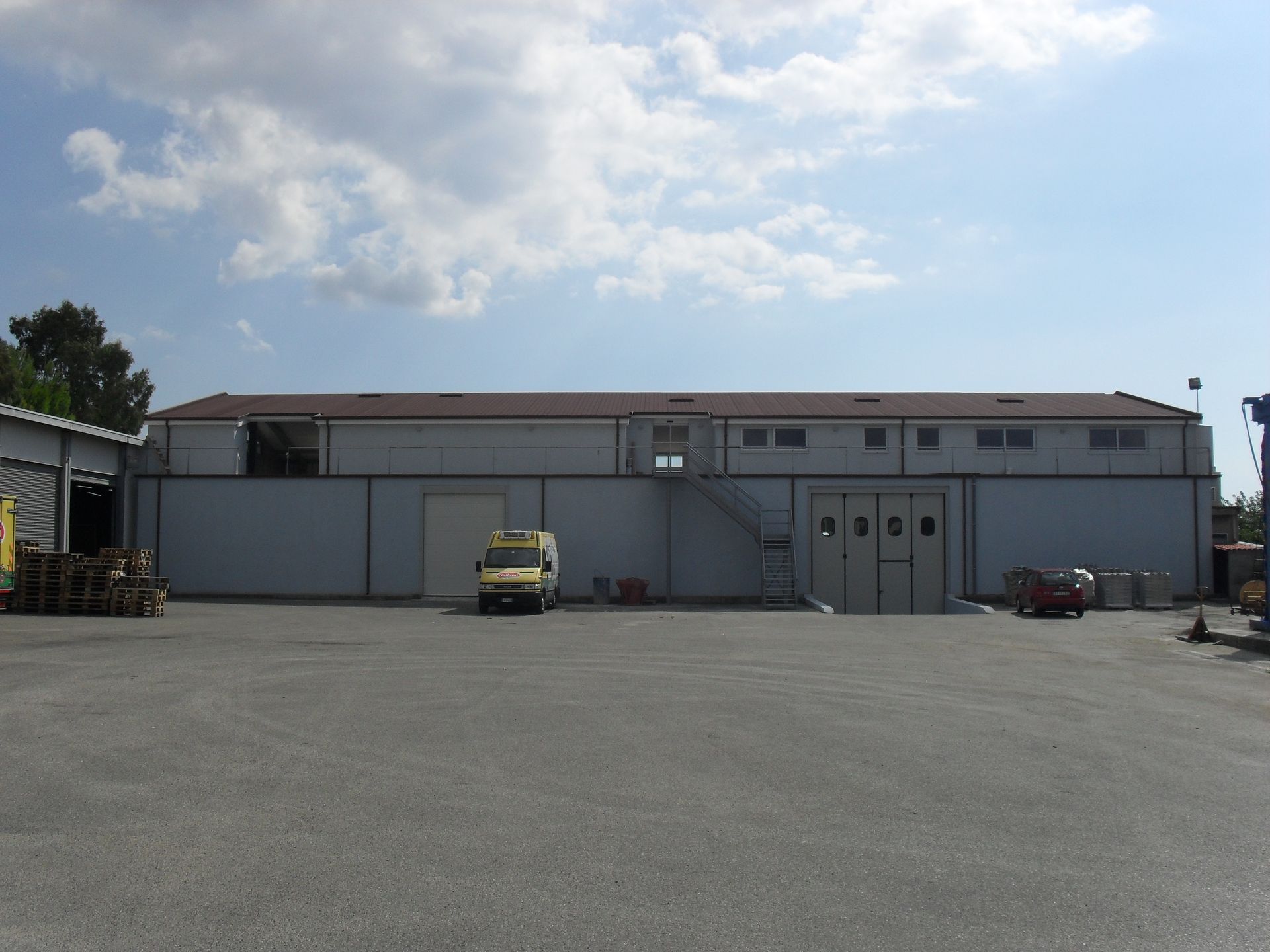 Un furgone giallo è parcheggiato davanti a un grande edificio