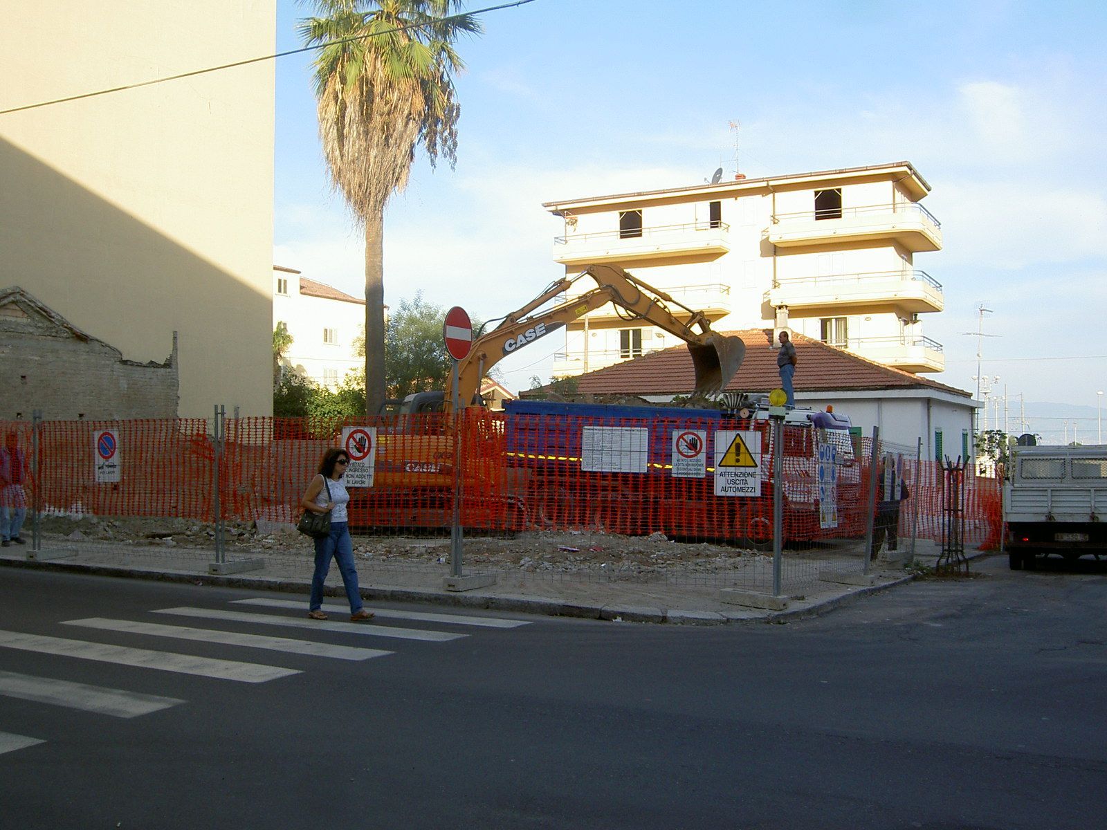 Una donna attraversa la strada davanti a un cantiere edile