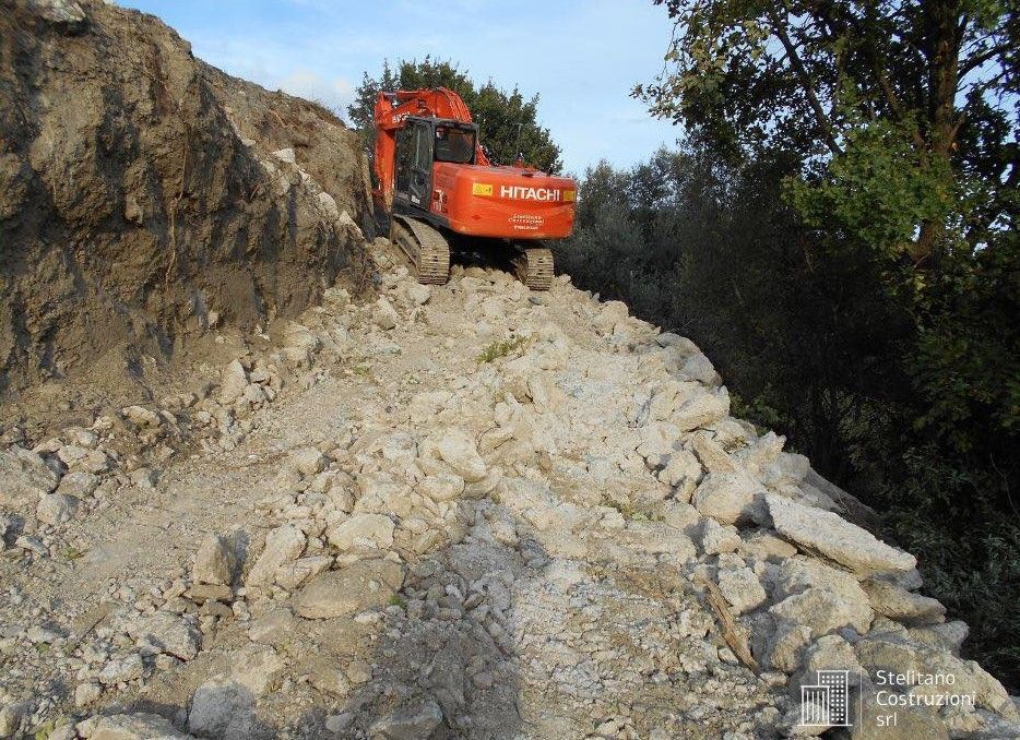 Un bulldozer sta scendendo da una collina di rocce.