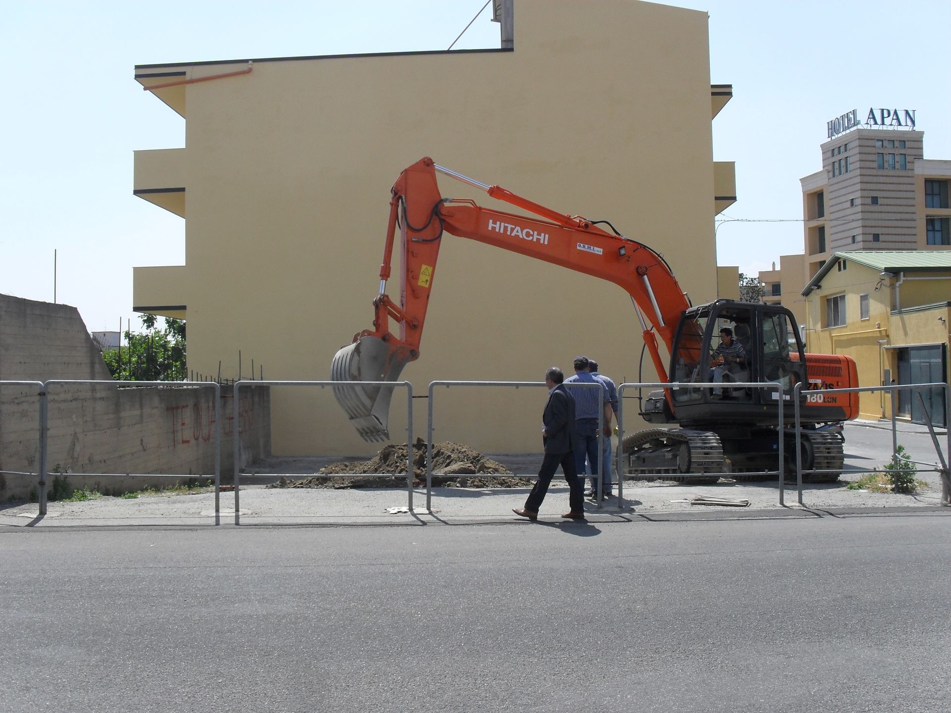 Un escavatore viene utilizzato per scavare una buca davanti a un edificio