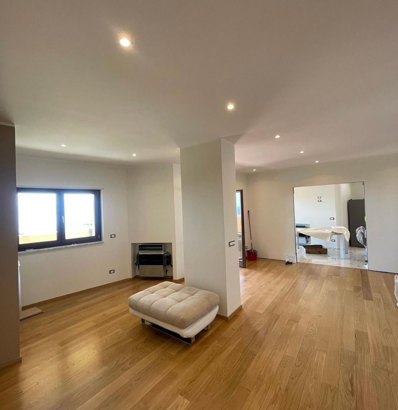 Un soggiorno con pavimenti in legno e pareti bianche