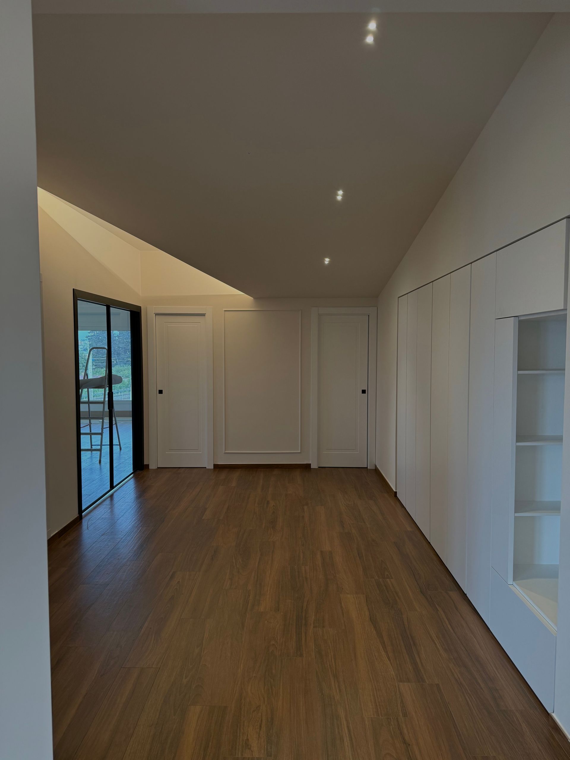 Una stanza vuota con pavimenti in legno e pareti bianche