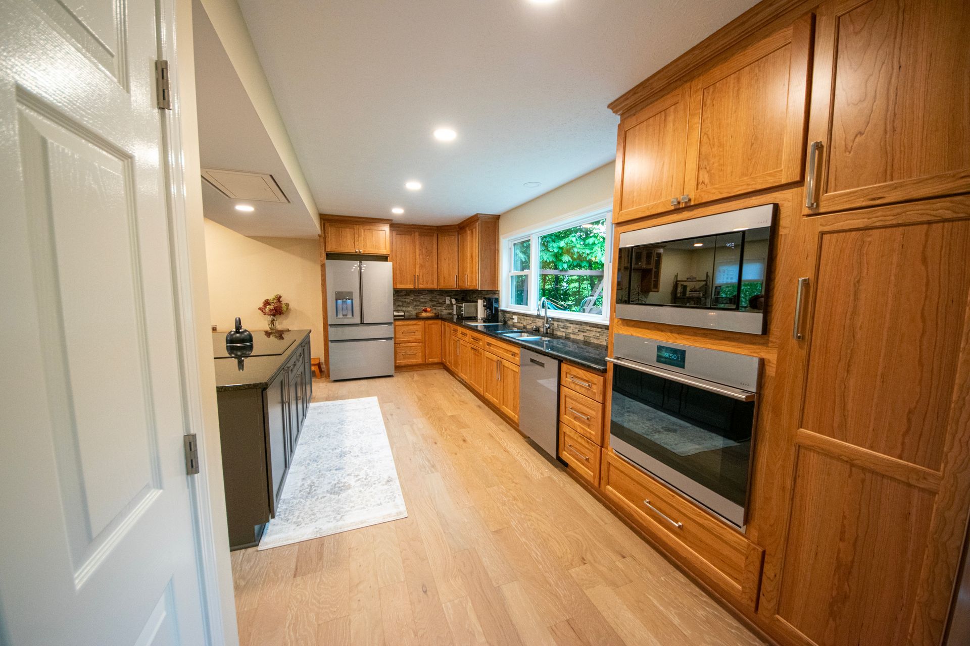 Bright kitchen with wood cabinets, stainless appliances, and light wood floors.