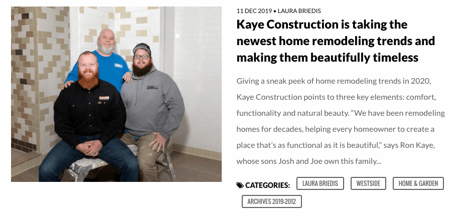 Three men in a room, posing for the camera. Text says 