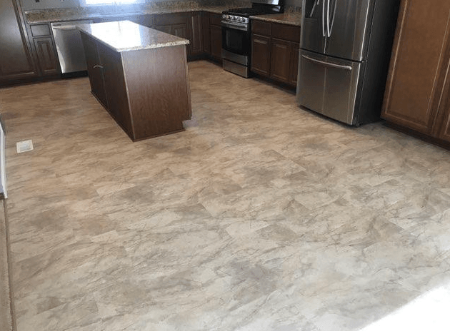 Kitchen with brown cabinets, stainless steel appliances, and neutral-toned flooring.