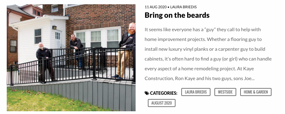 Men standing on a ramp in front of a building. The ramp is grey with black railing.