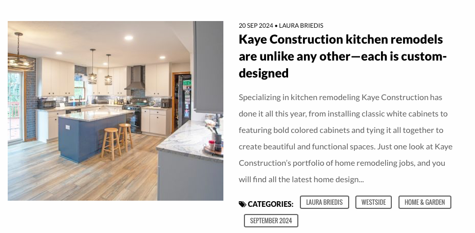 Kitchen remodel by Kaye Construction, featuring a blue island, light wood floors, and white cabinets.