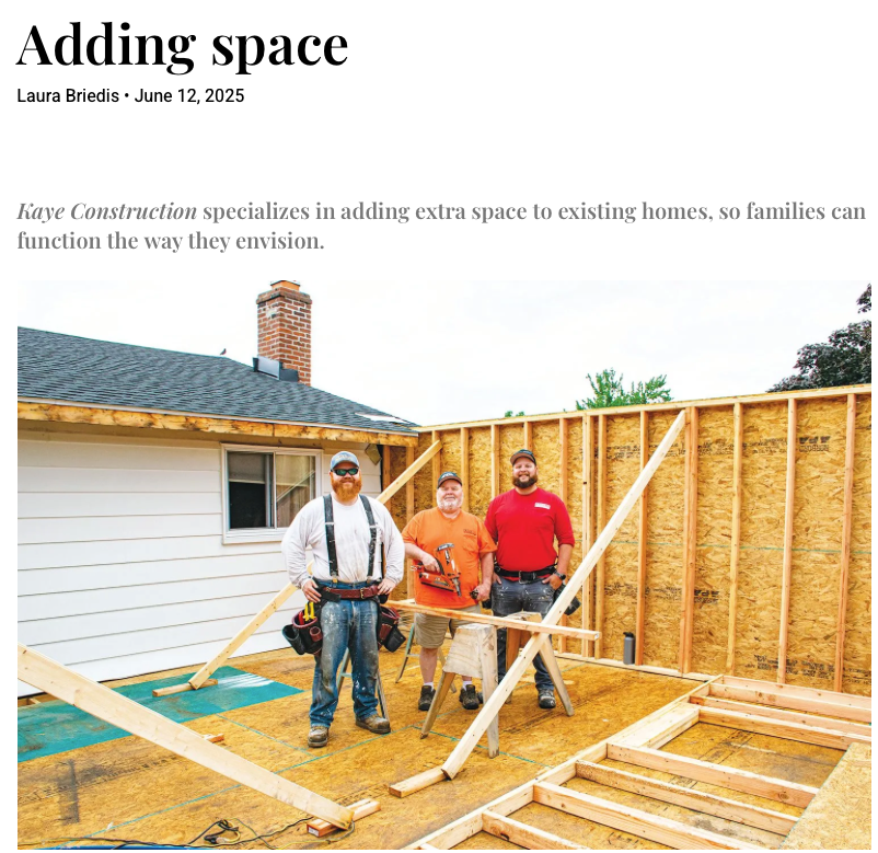 Three construction workers building an addition to a house.