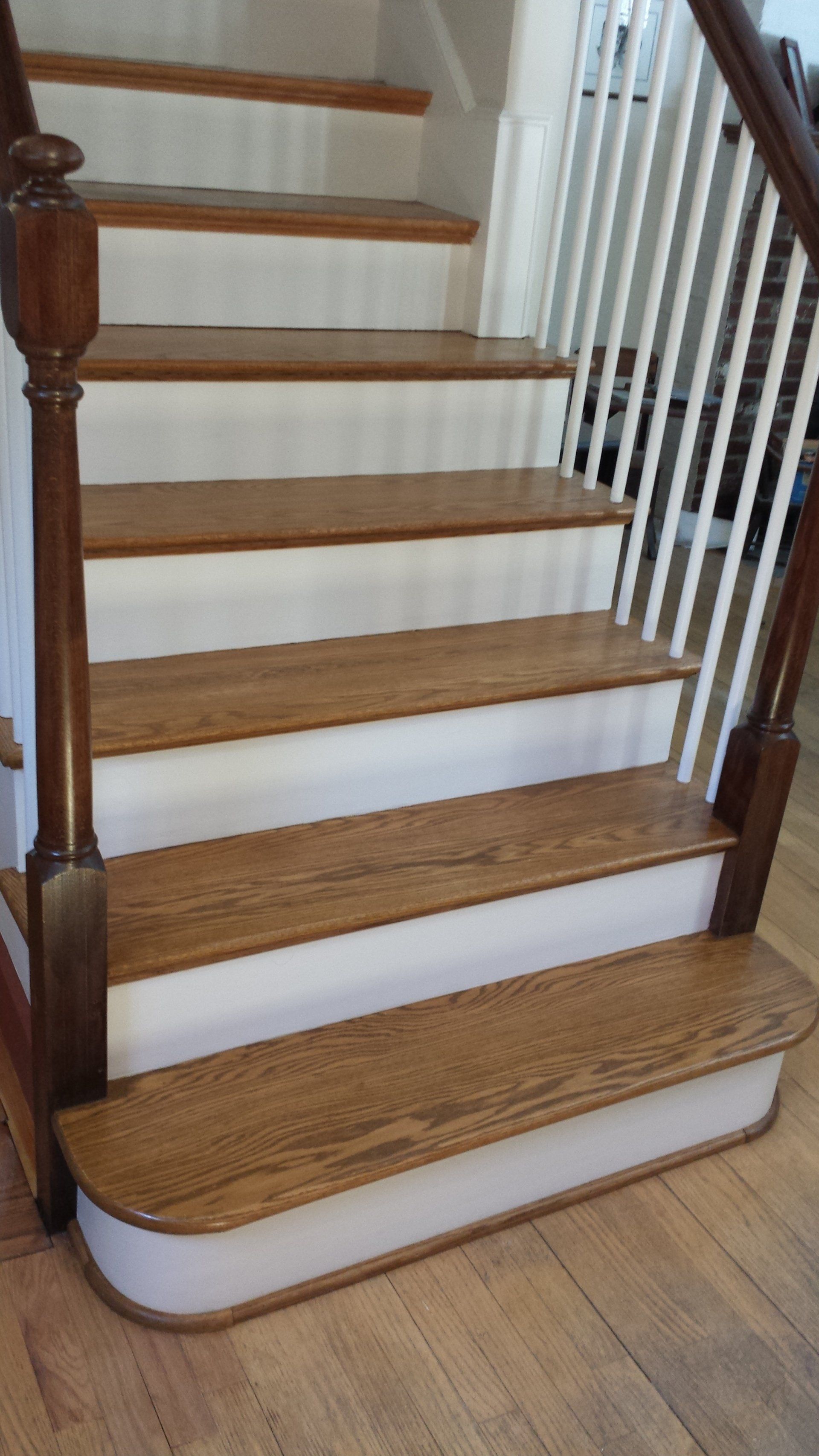 a wooden staircase with white steps and a wooden railing.