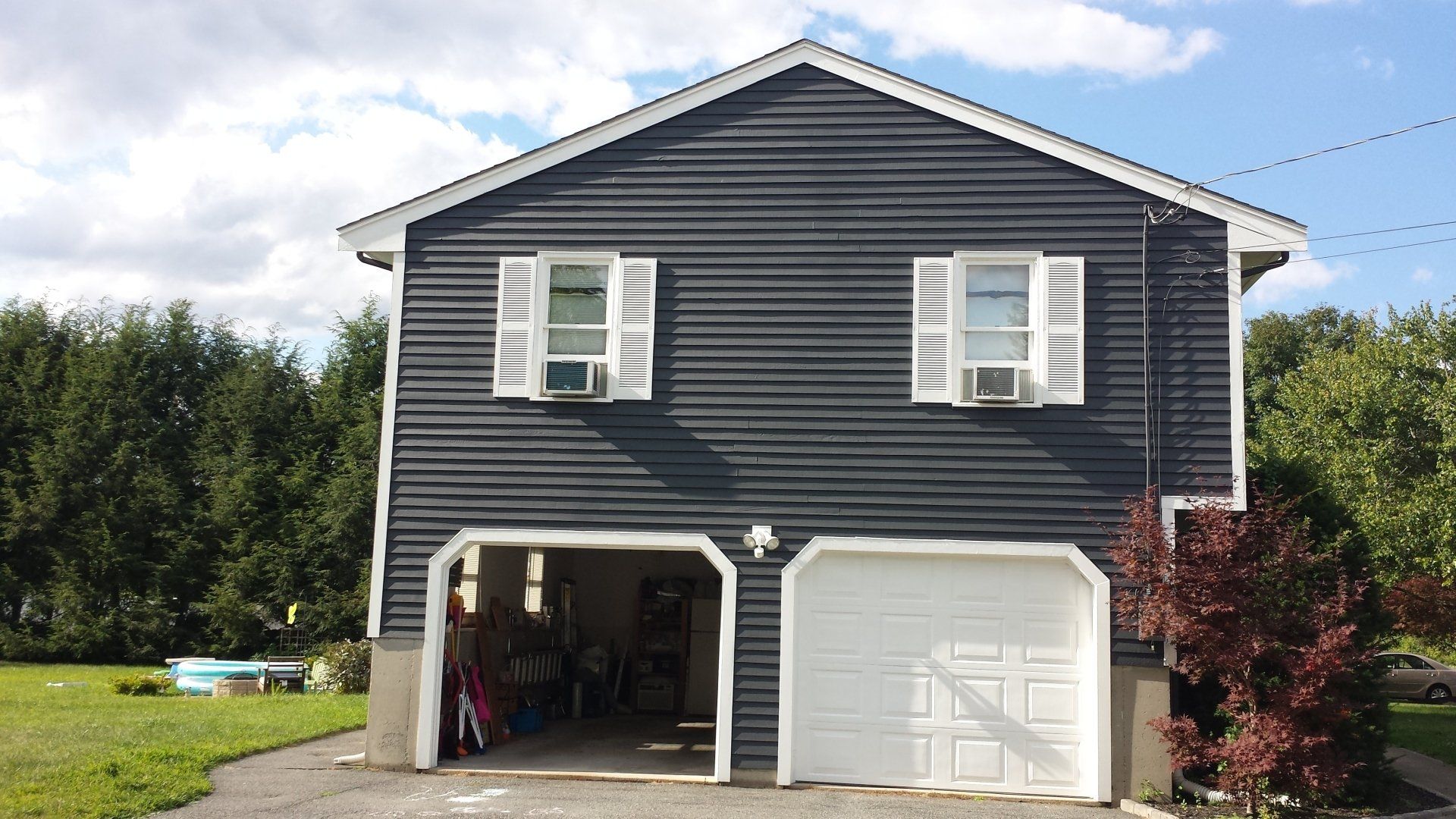 a black house with two garage doors and white shutters