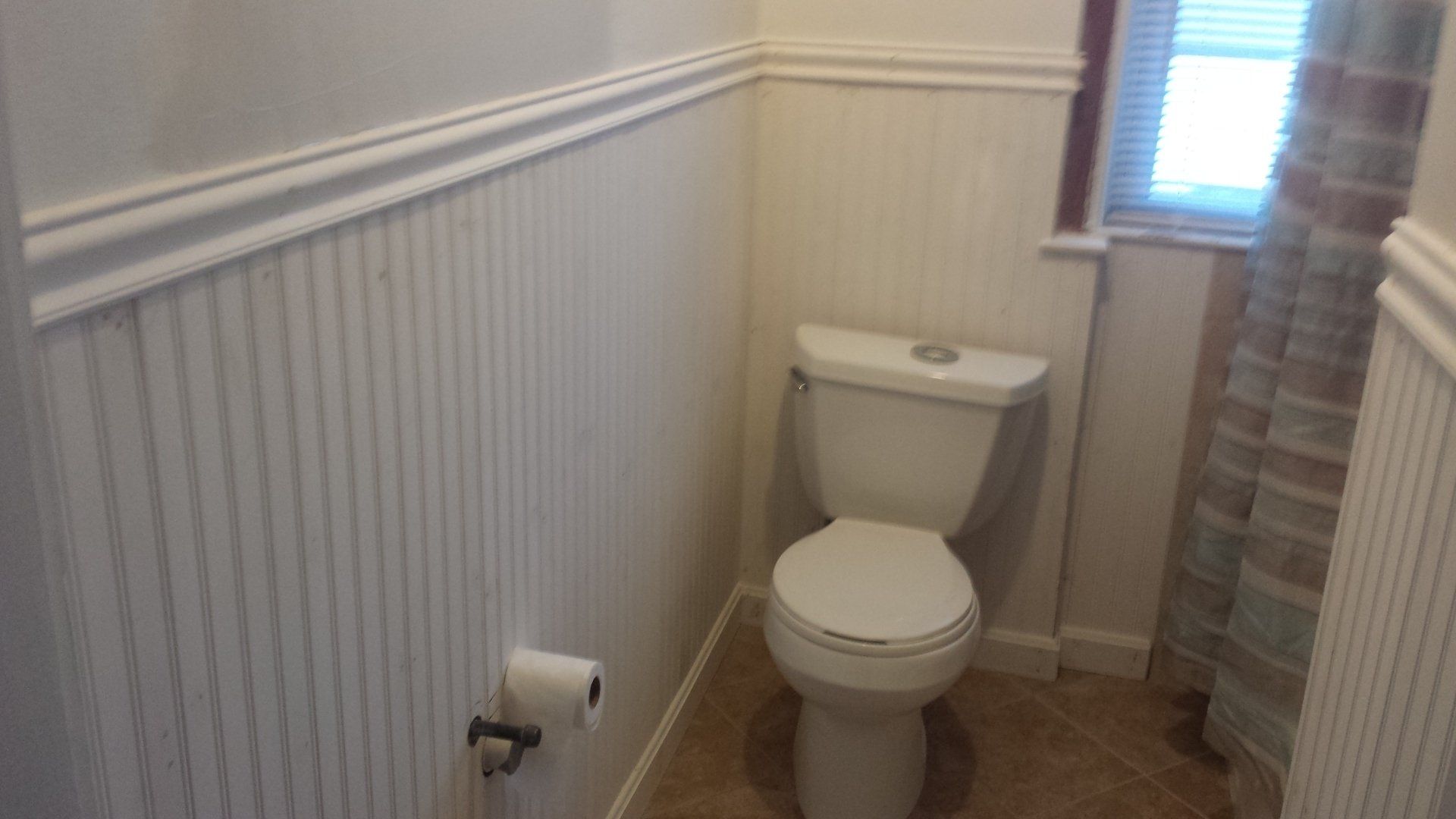 a bathroom with a toilet and a shower curtain.