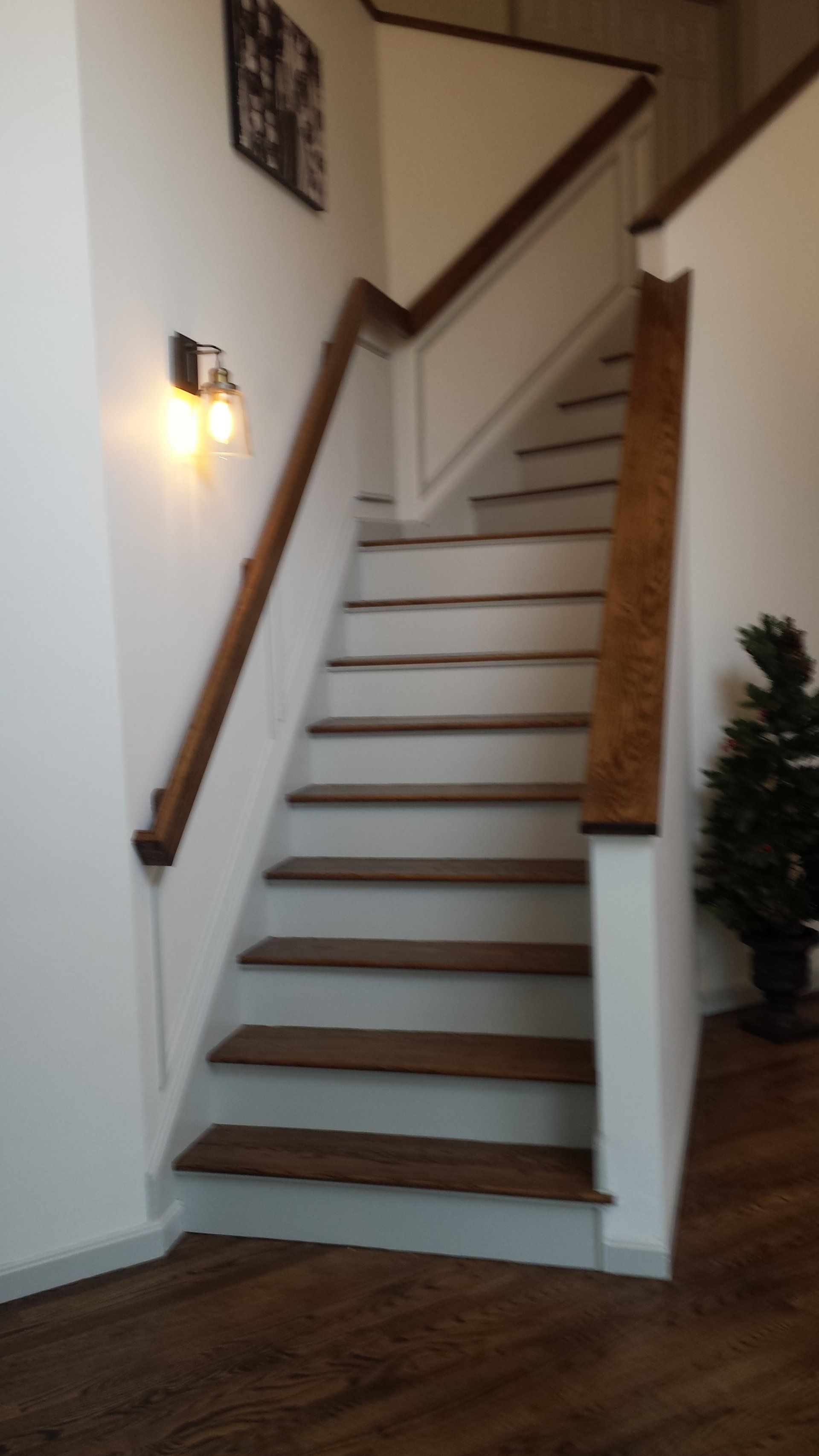 a staircase with wooden steps and a white railing in a house.