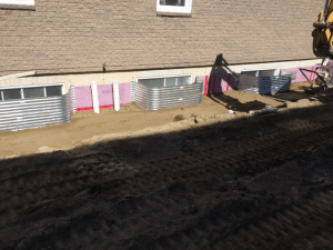 Une grande excavatrice est assise devant une maison.