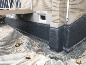 Un bâtiment en briques avec une bâche noire sur le côté.