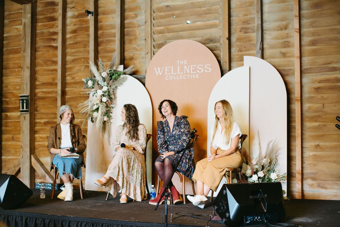 A group of women are sitting on a stage in front of a microphone.