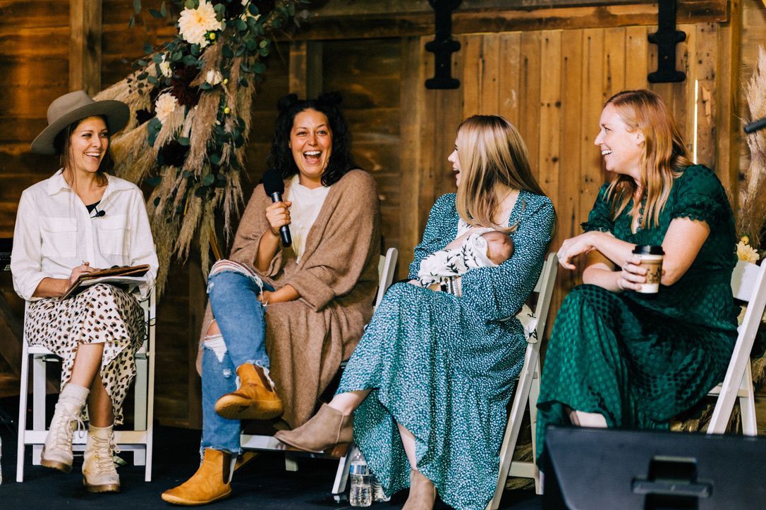 A group of women are sitting in chairs talking to each other.