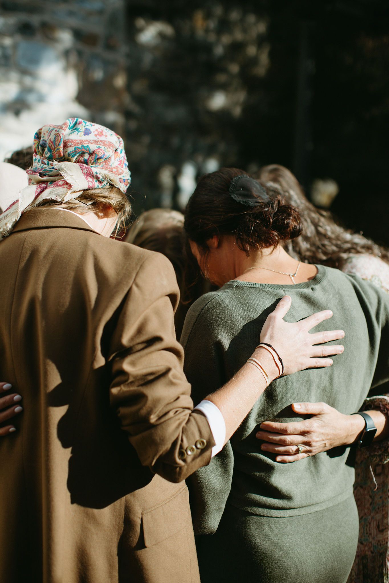 A group of women are hugging each other in a circle.