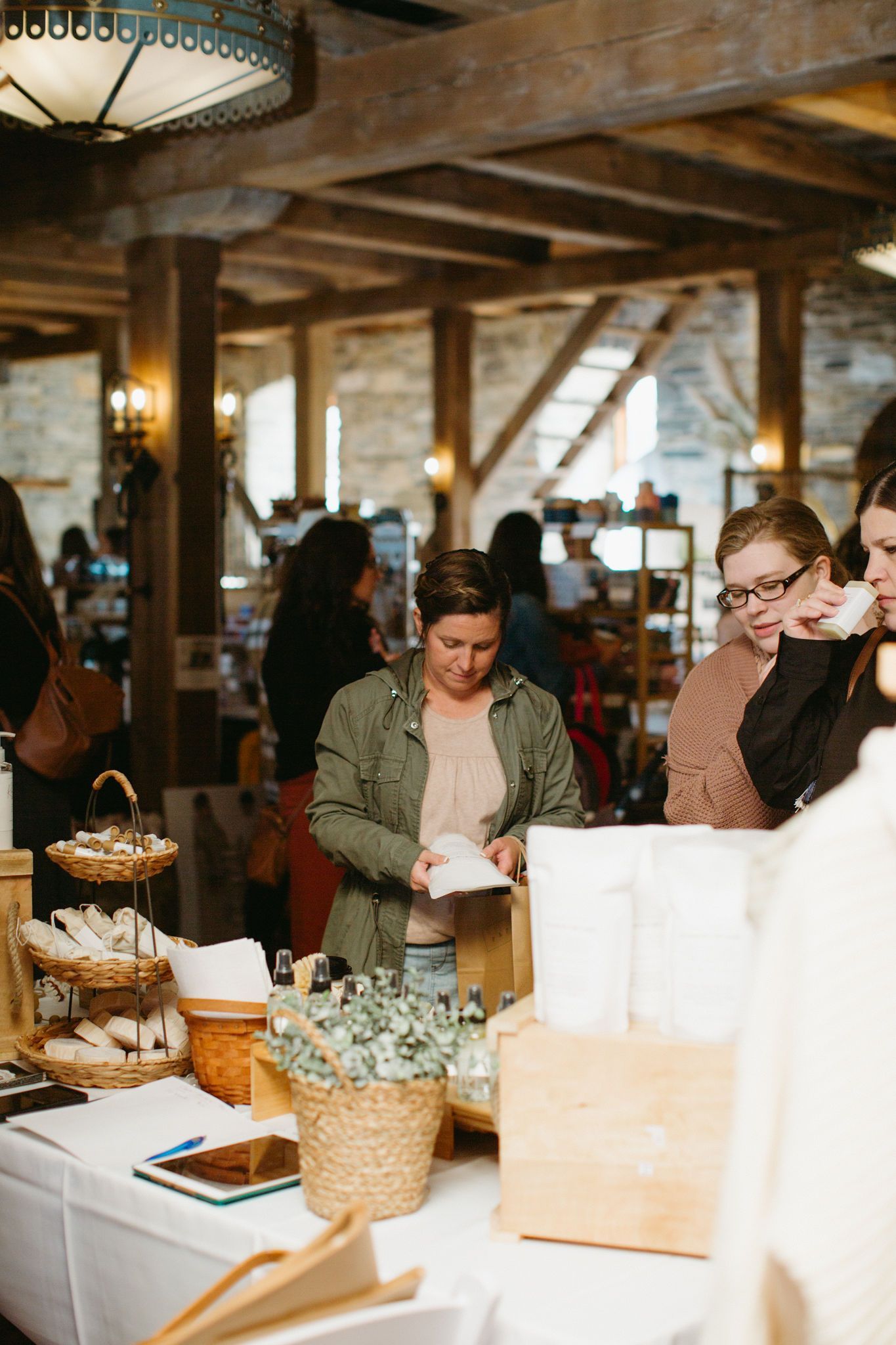 A group of people are standing around tables at a market.