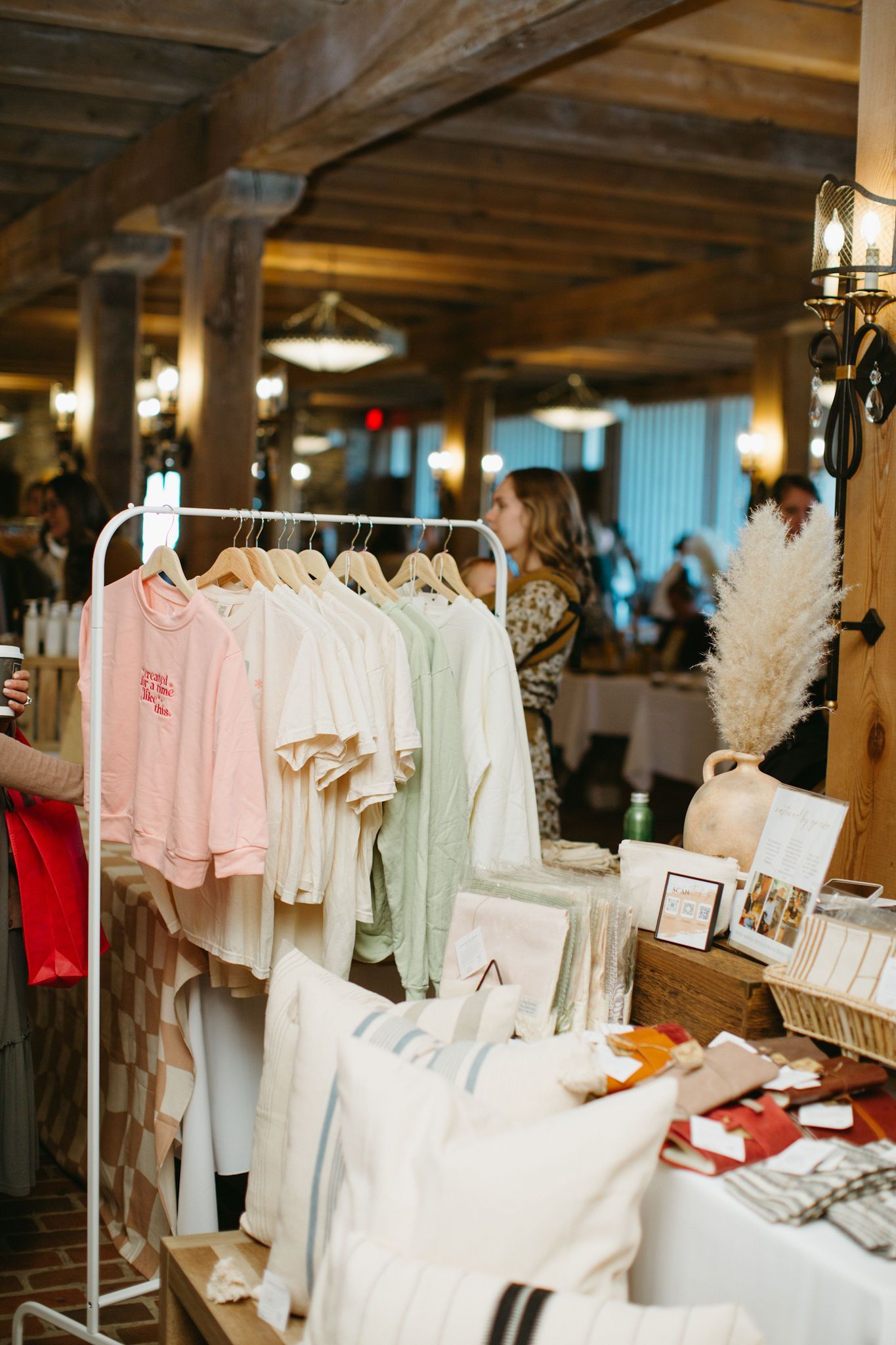A woman is standing in front of a rack of clothes.