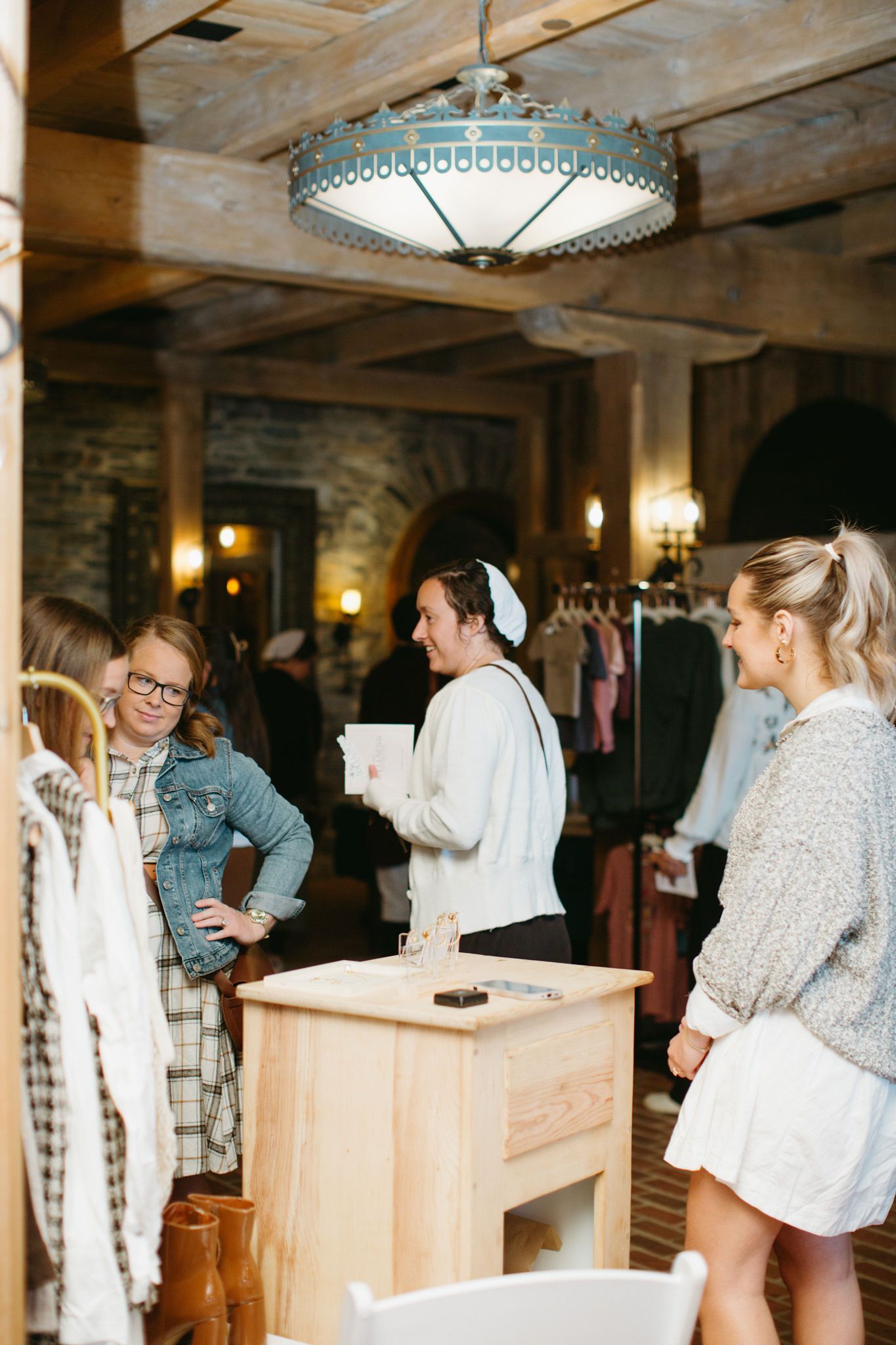 A group of women are standing around a table in a room.