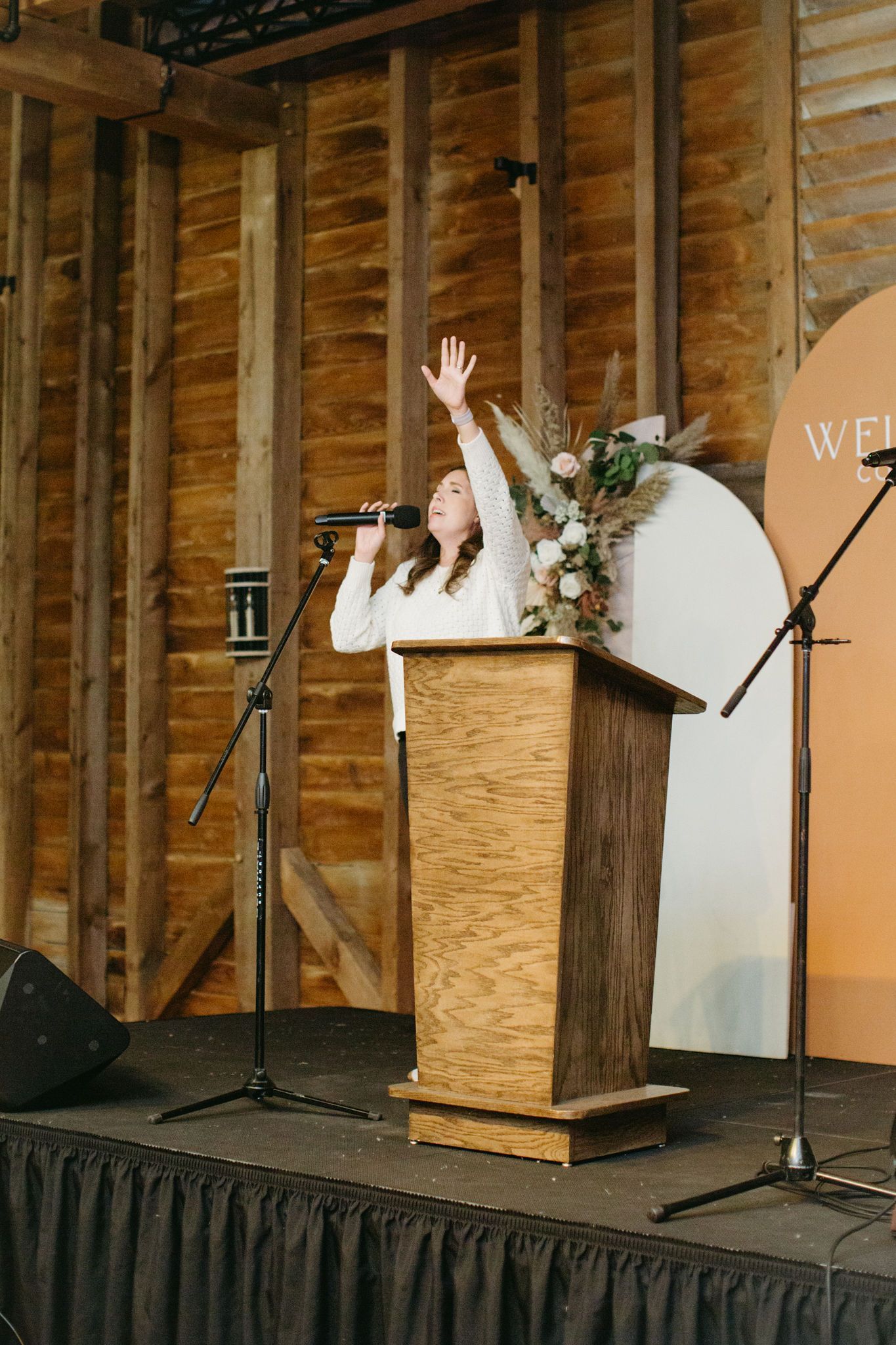 A woman is standing at a podium speaking into a microphone.