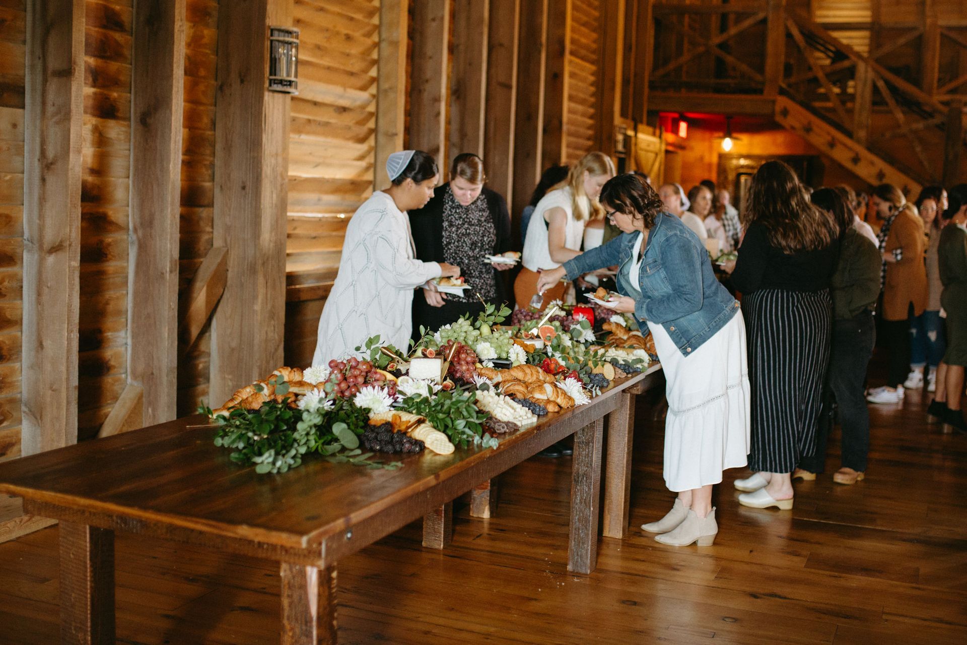A group of people are standing around a long wooden table.