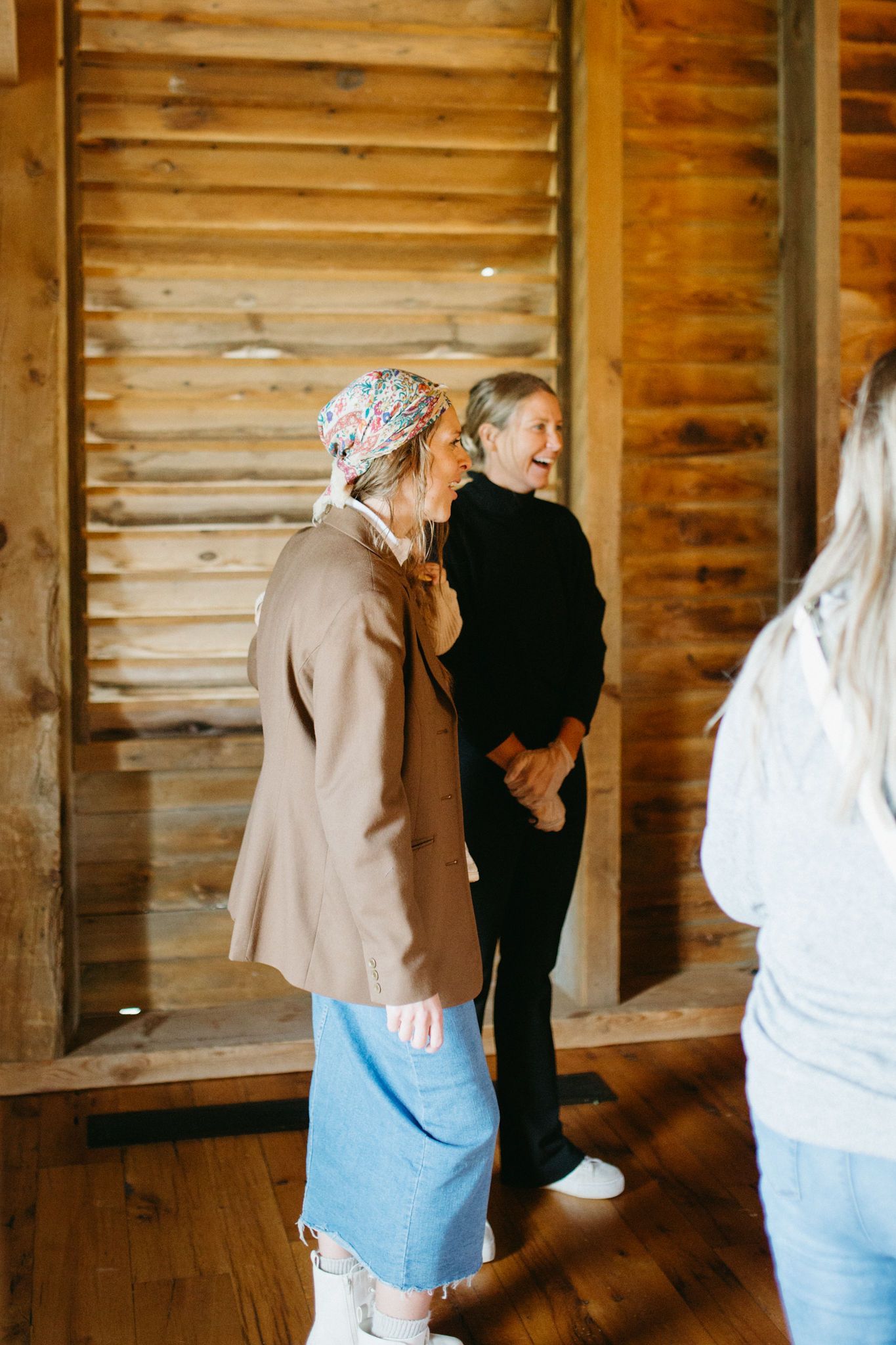 A group of women are standing next to each other in a wooden room.