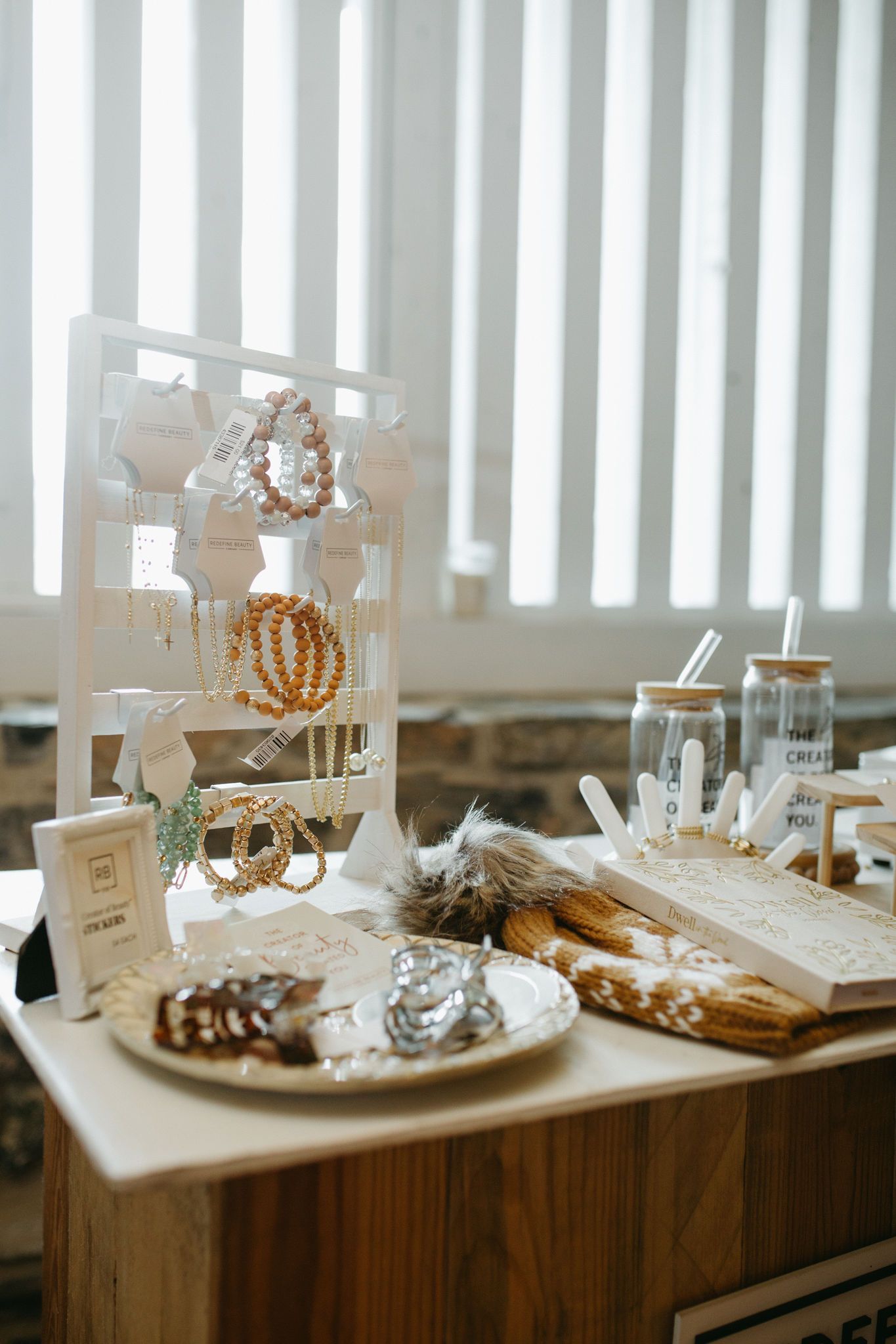 A table with a plate of food and a display of jewelry on it.