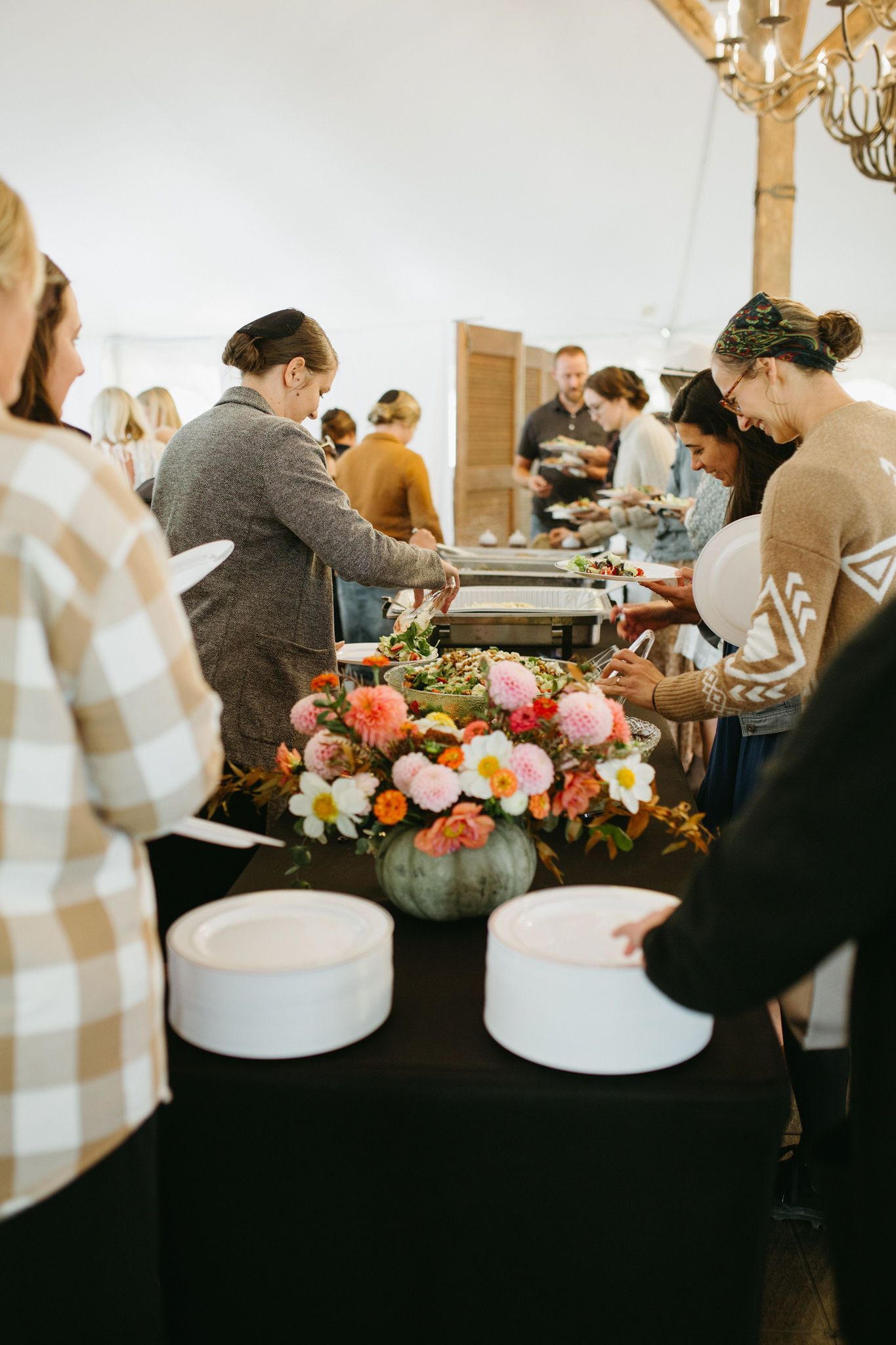 A group of people are standing around a buffet table.