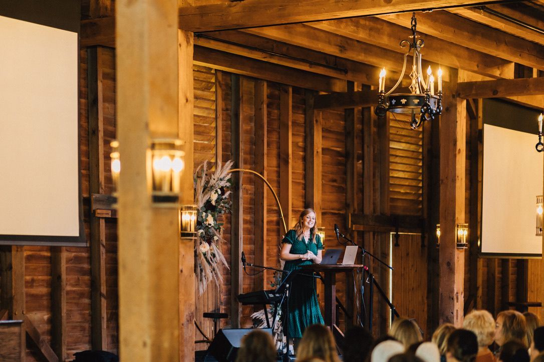 A woman is standing at a podium giving a presentation to a group of people.