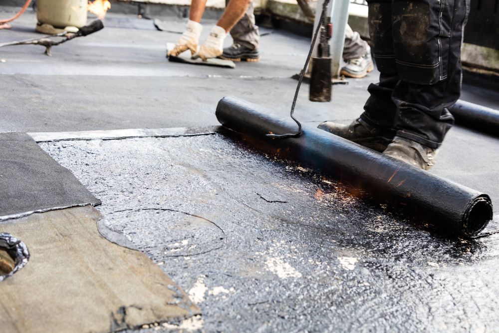 Workers Applying Roofing Material With a Torch on a Flat Roof — 1 Time Waterproofing In East Ballina, NSW