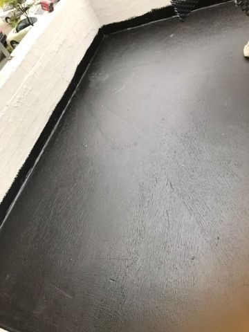 Black Flat Roof With Sealed Edges, Near a White Wall — 1 Time Waterproofing In Tweed Heads, NSW