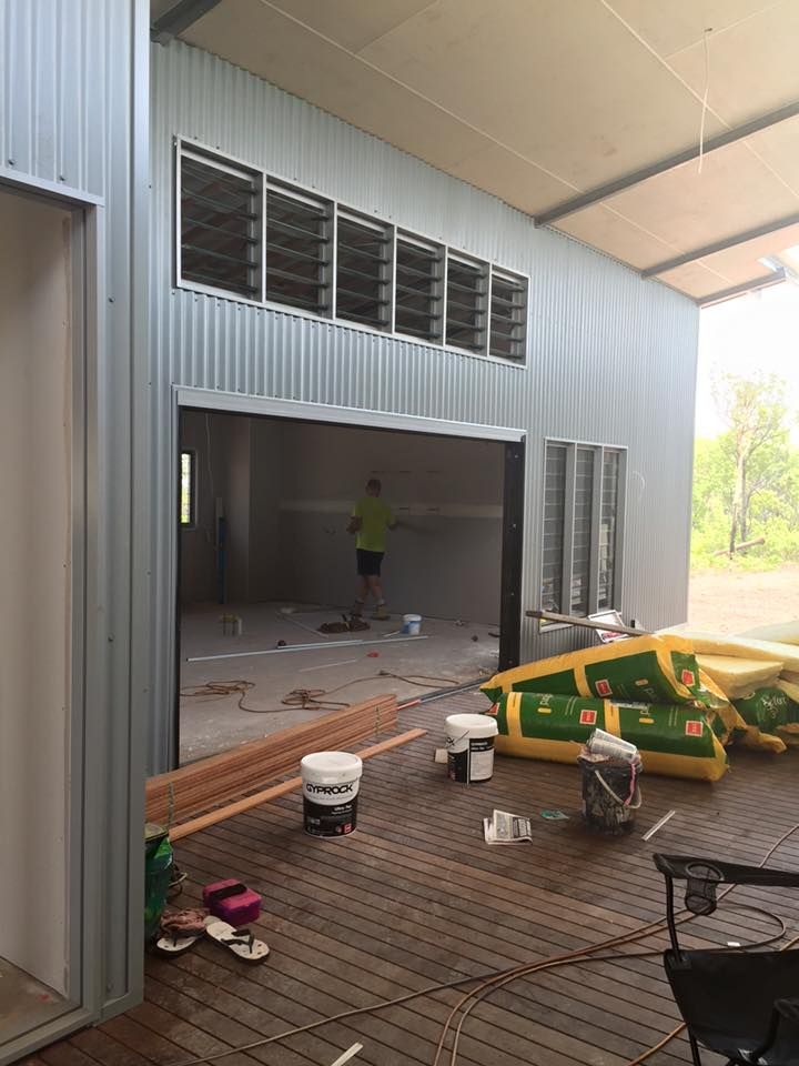 A Man Is Painting The Inside Of A Building — SLS Builders Pty Ltd in Katherine, NT