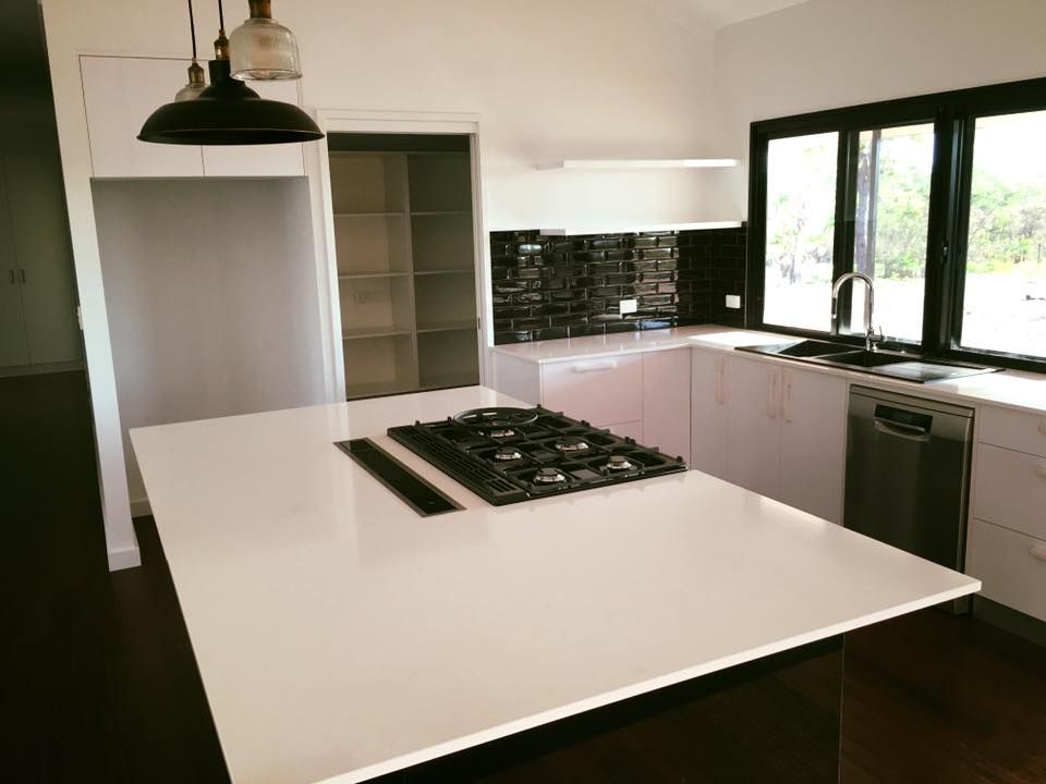 A Kitchen With A Large Island And A Stove Top Oven — SLS Builders Pty Ltd in Alice Springs, NT