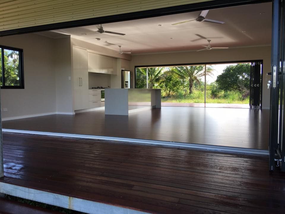 A Large Empty Room With Hardwood Floors And Sliding Glass Doors — SLS Builders Pty Ltd in Kununurra, WA