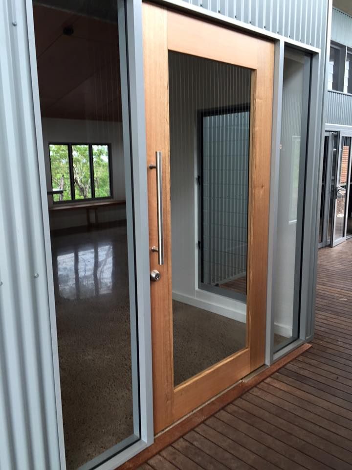 A Wooden Door With A Glass Window Is Open To An Empty Room — SLS Builders Pty Ltd in Humpty Doo, NT