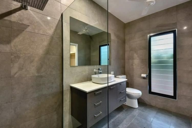 A Bathroom With a Sink, Toilet, Mirror and Walk in Shower — SLS Builders Pty Ltd in Humpty Doo, NT