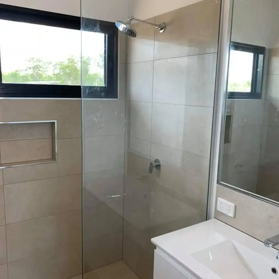 A Bathroom With a Sink and a Shower With a Glass Door — SLS Builders Pty Ltd in Humpty Doo, NT