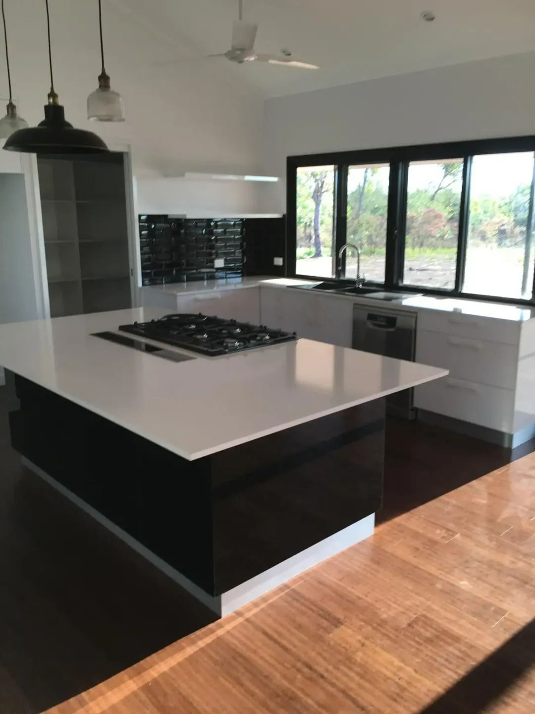A Kitchen With a Large Island and a Stove Top Oven — SLS Builders Pty Ltd in Humpty Doo, NT