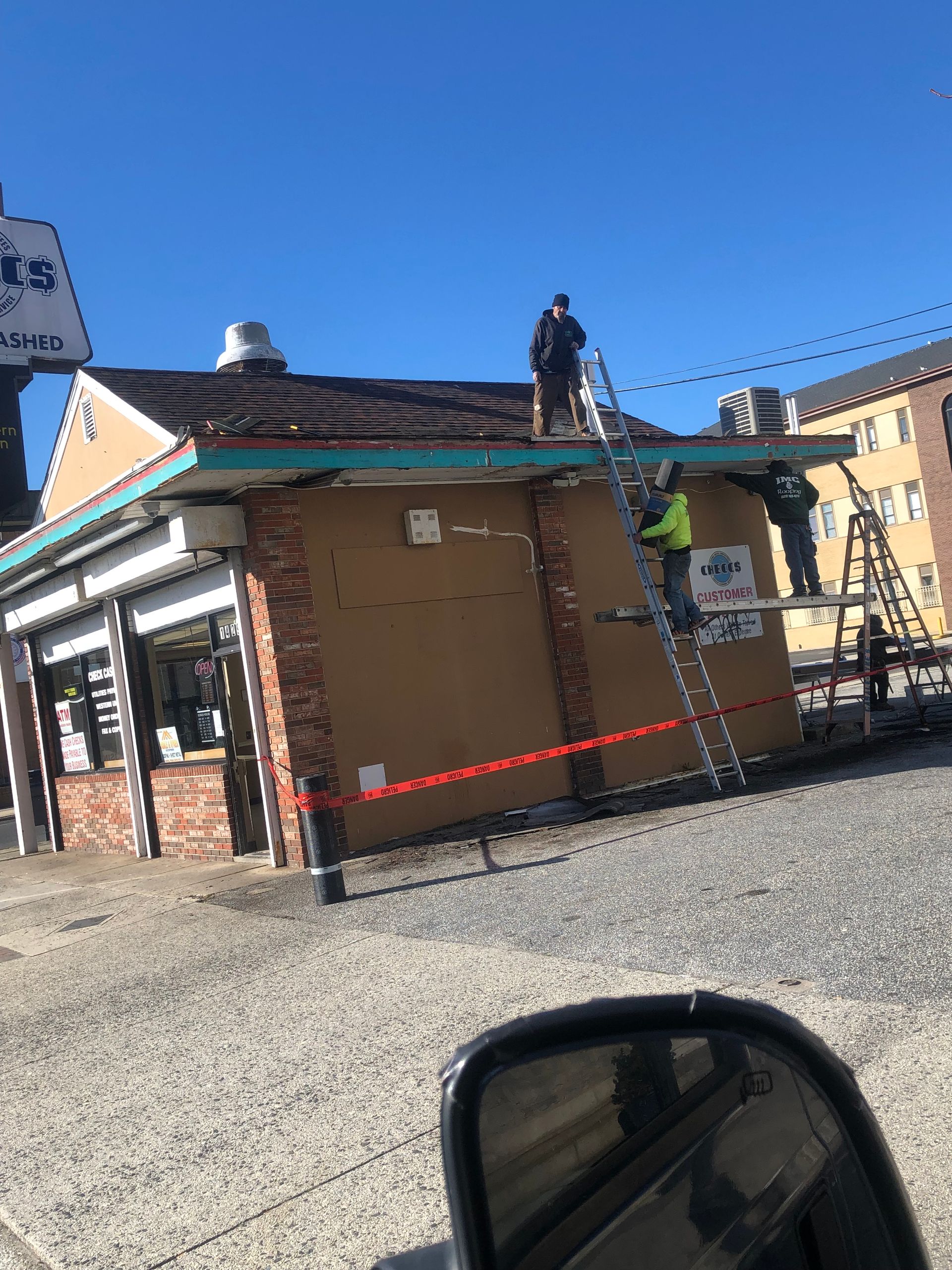 A group of men are working on the roof of a building.