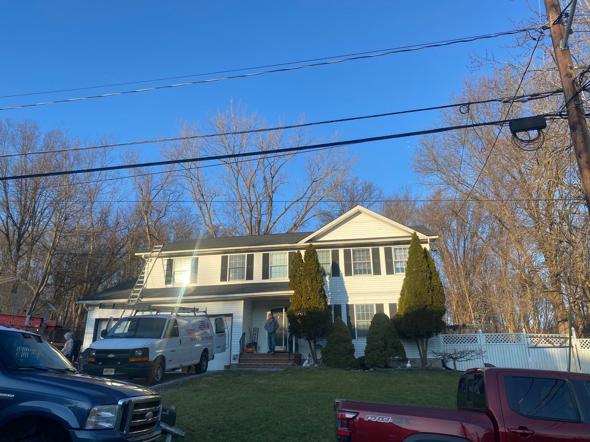 A large white house with a red truck parked in front of it