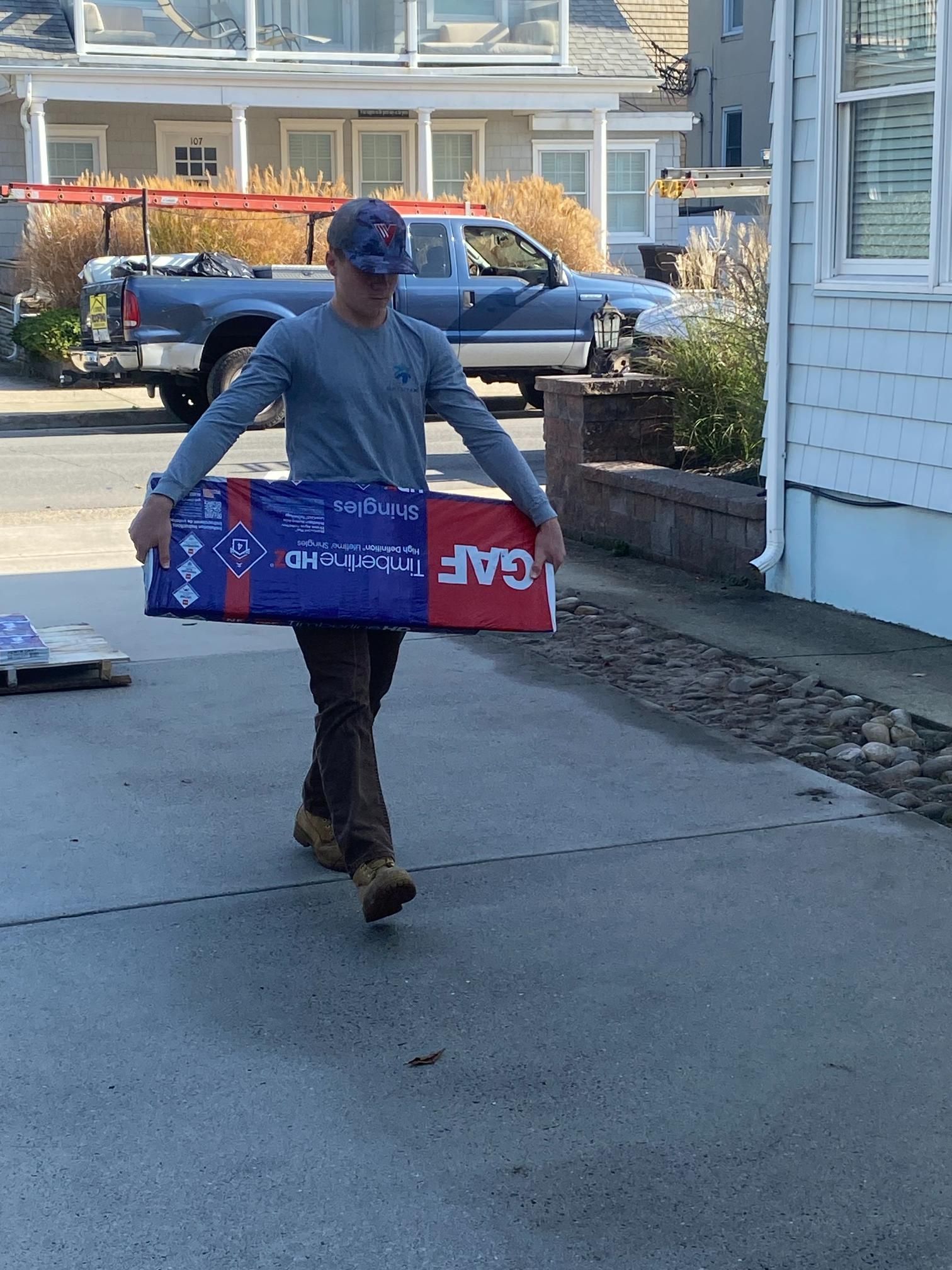 A man is carrying a box that says gaf on it
