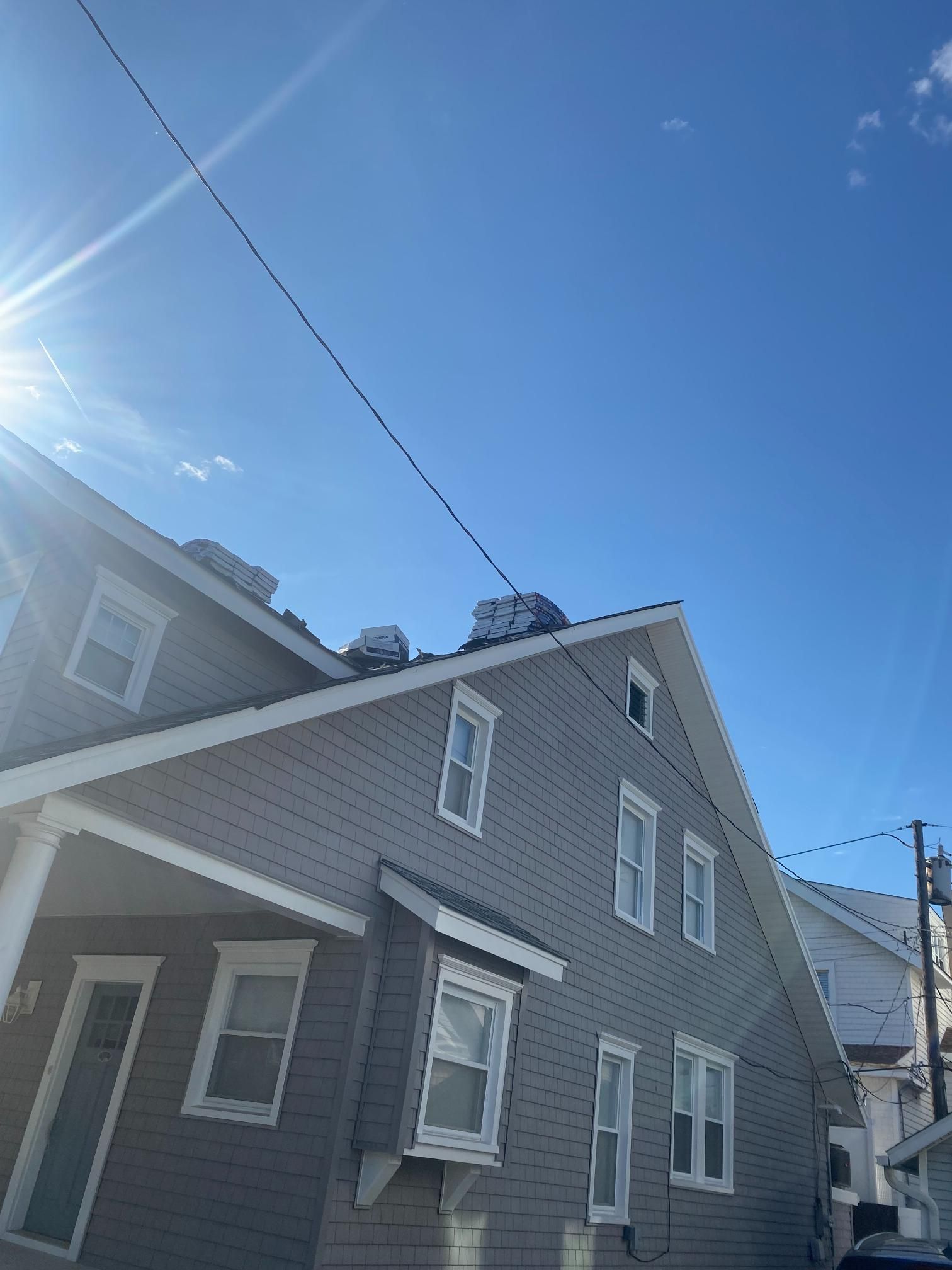 A large gray house with a blue sky in the background.