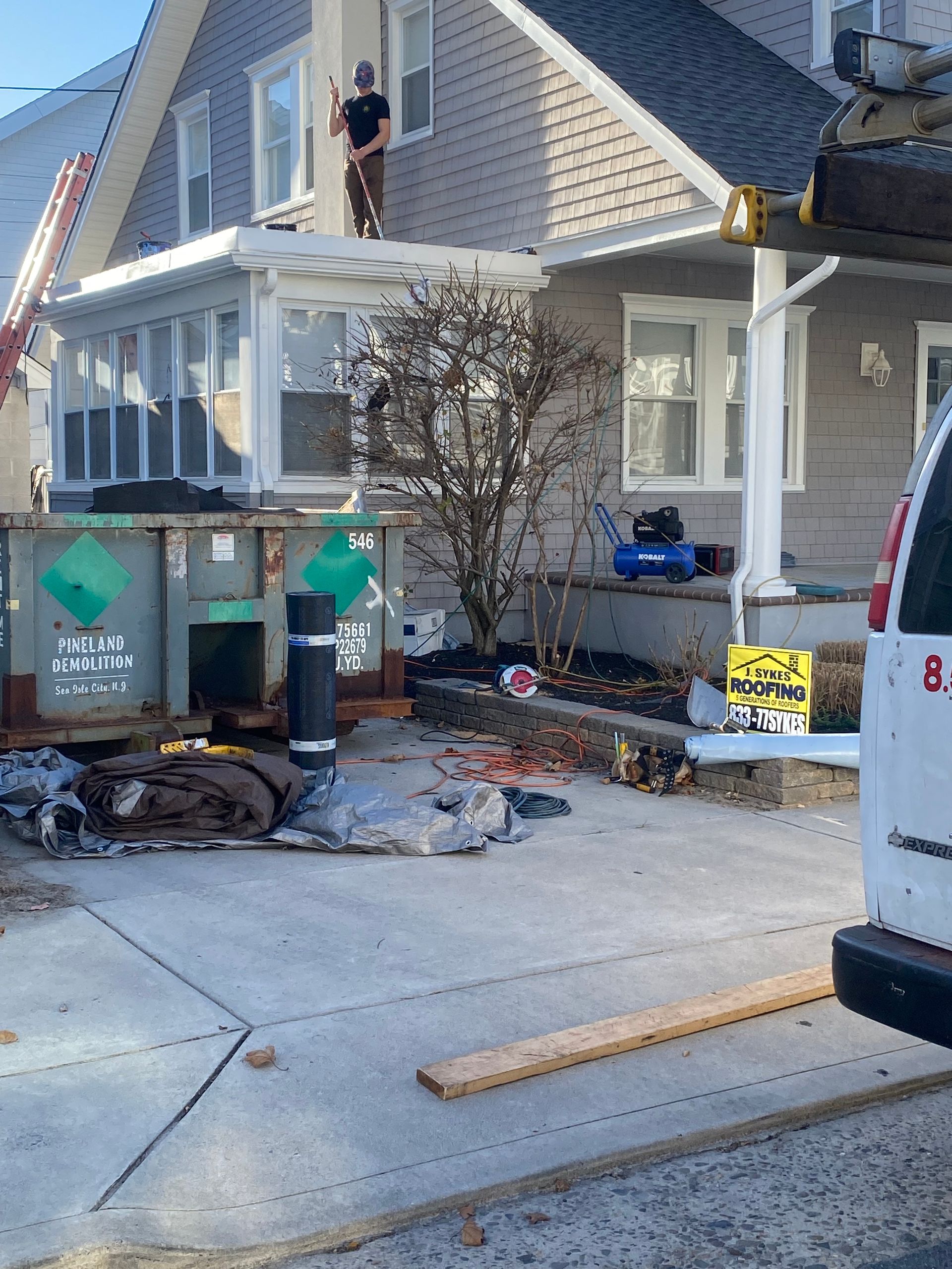 A white van is parked in front of a house