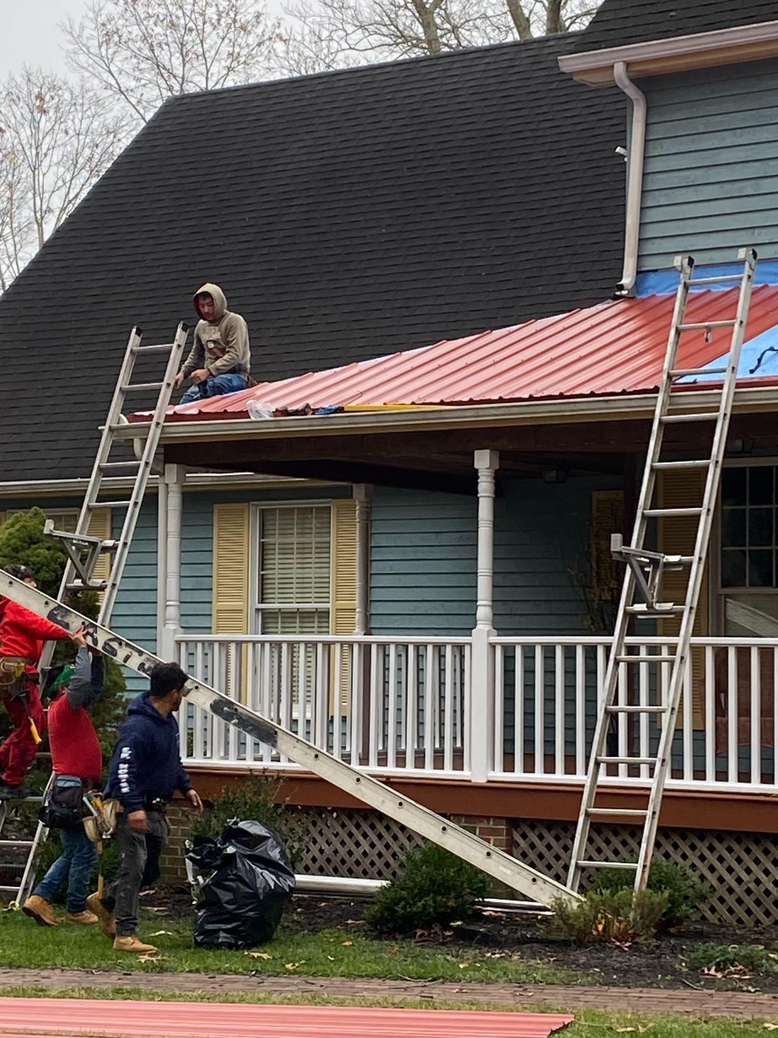 A group of people are working on the roof of a house.