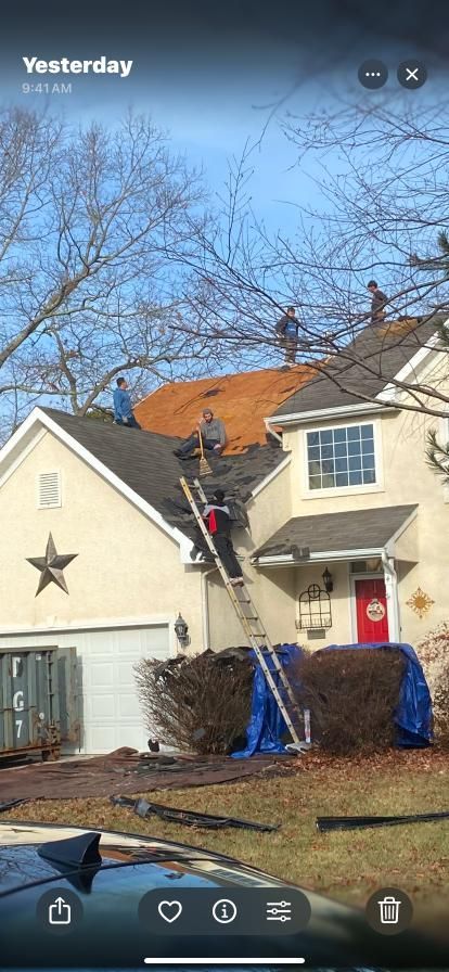 A group of people are working on the roof of a house.
