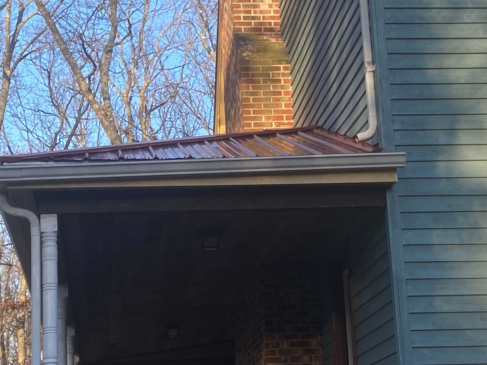 A house with a brick chimney and a metal roof