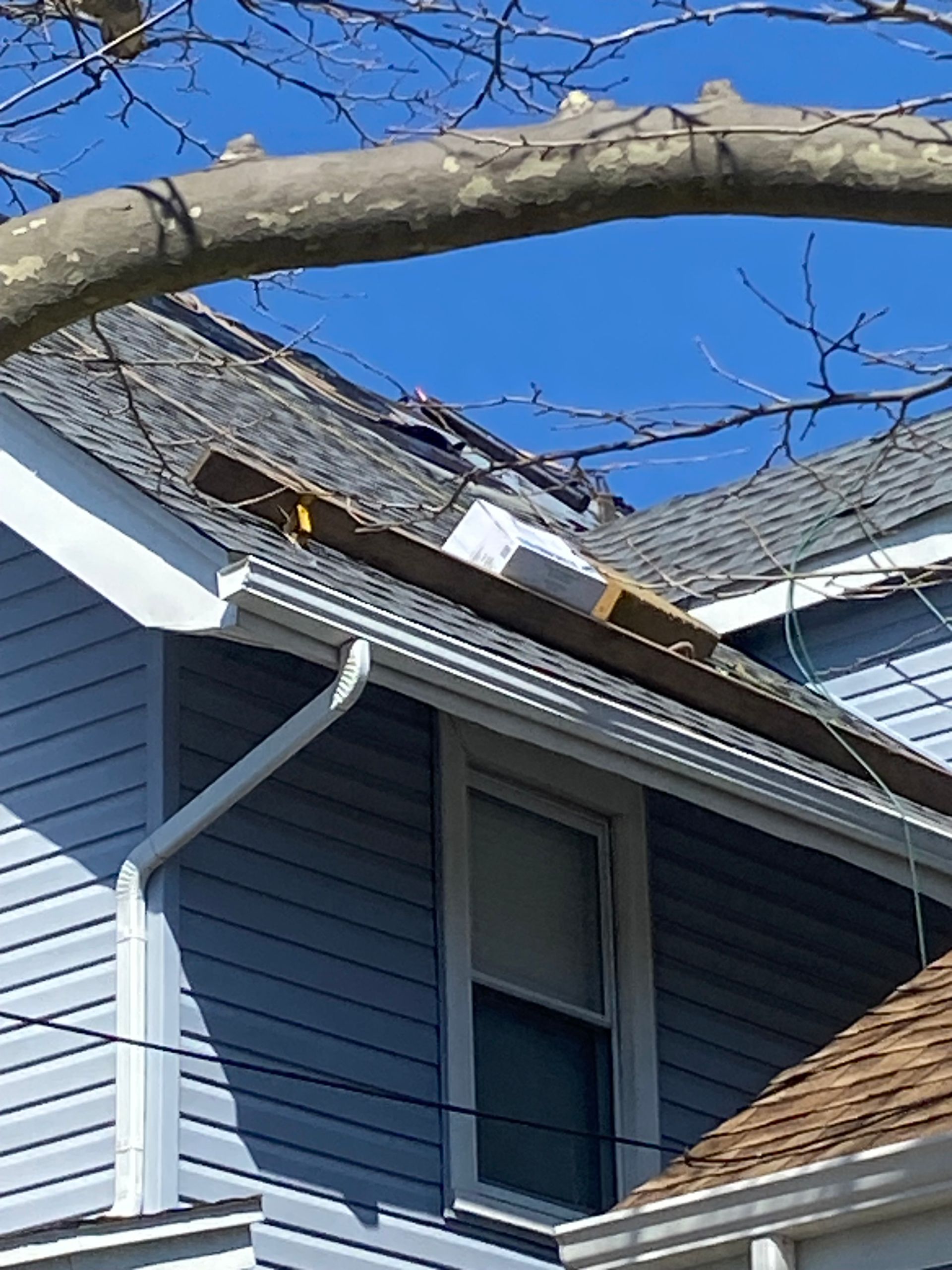 A blue house with a roof that is being repaired