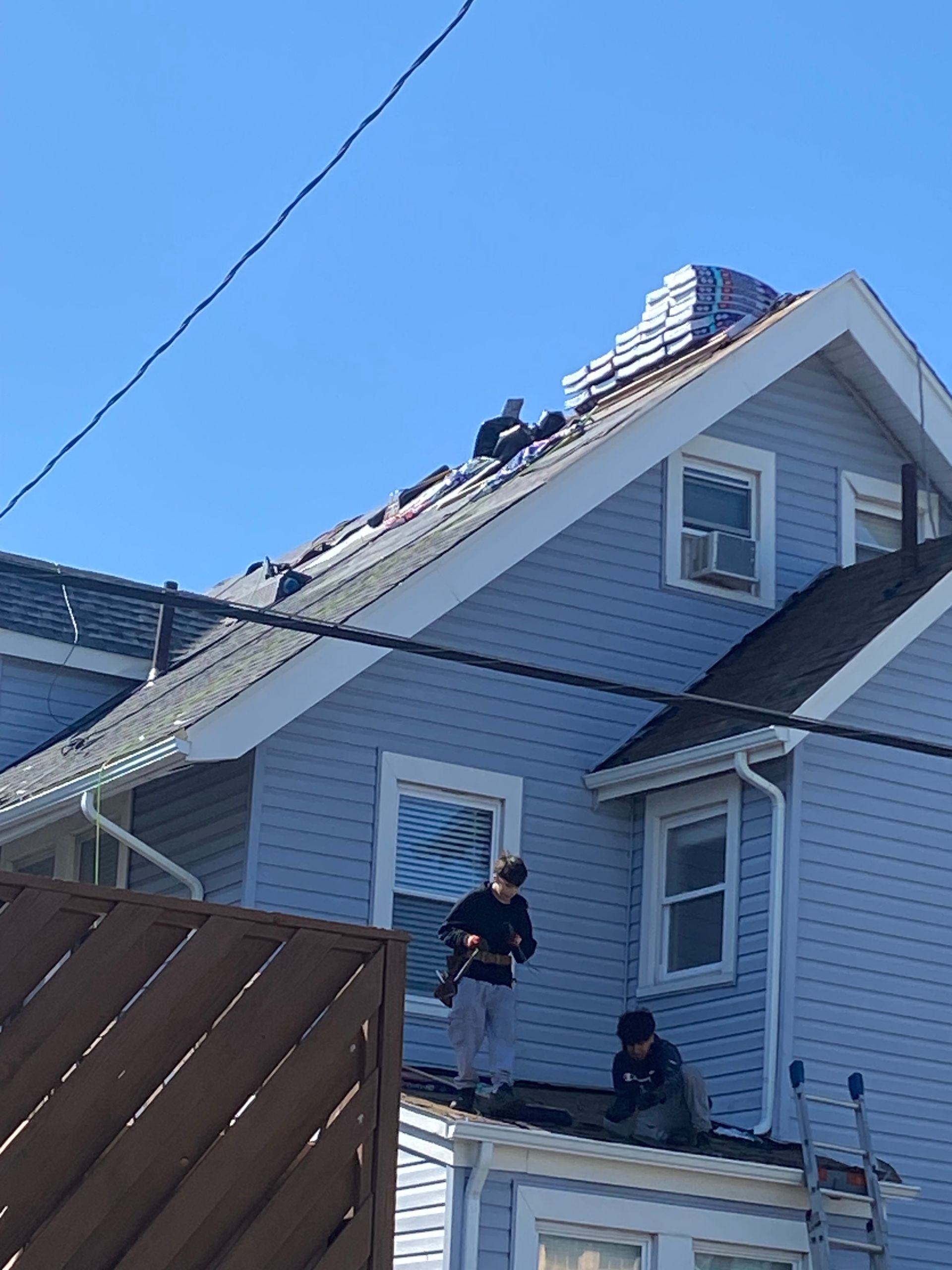 Two men are working on the roof of a house.