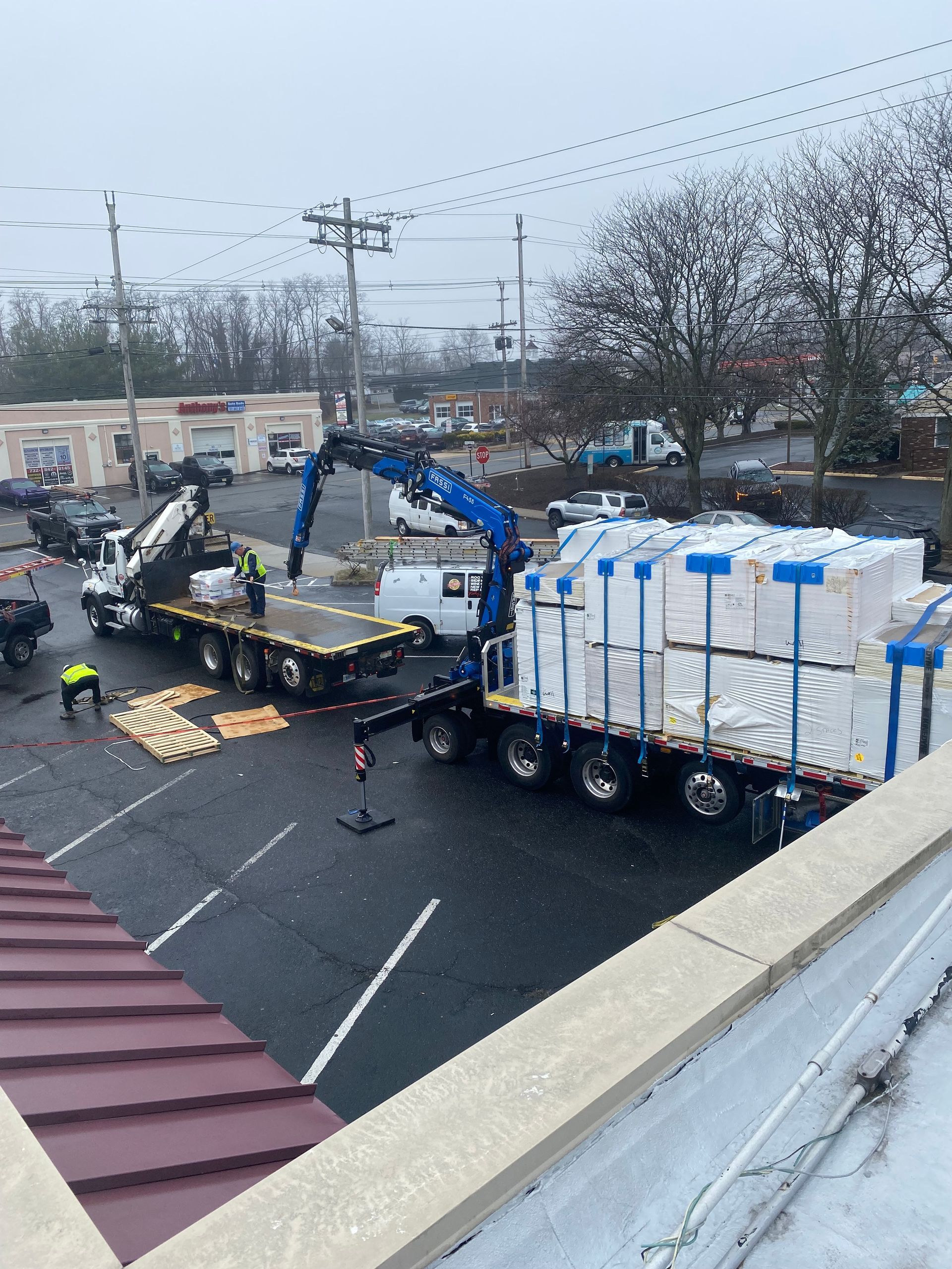 A truck with a crane on the back of it is being loaded with boxes.